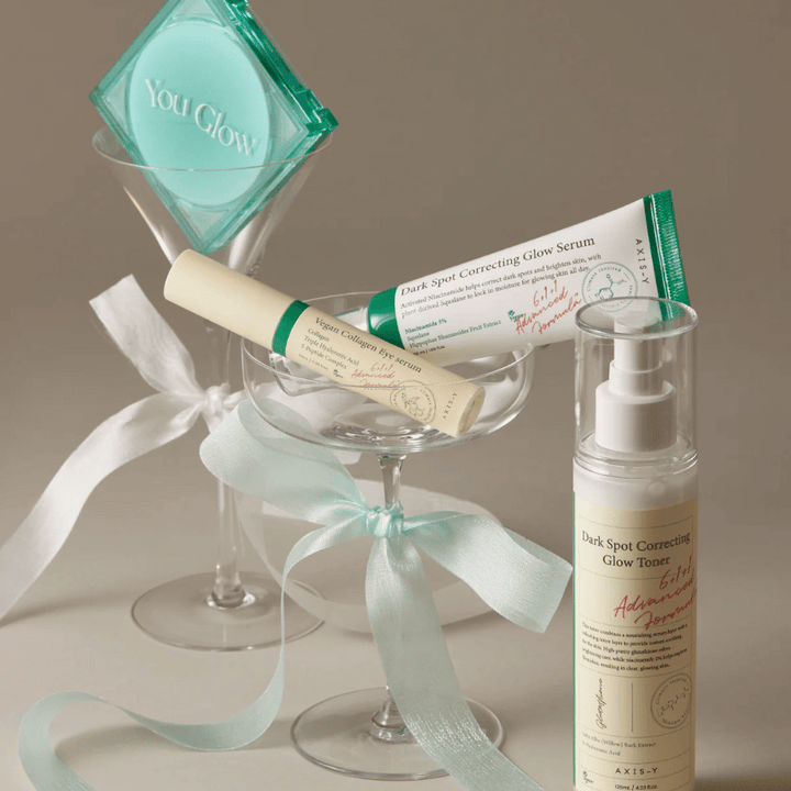 Bild på hudvårdskit från AXIS-Y med ögonserum, serum och toner – elegant placerade i cocktailglas med sidenband, perfekt för en lyxig gåvopresentation.