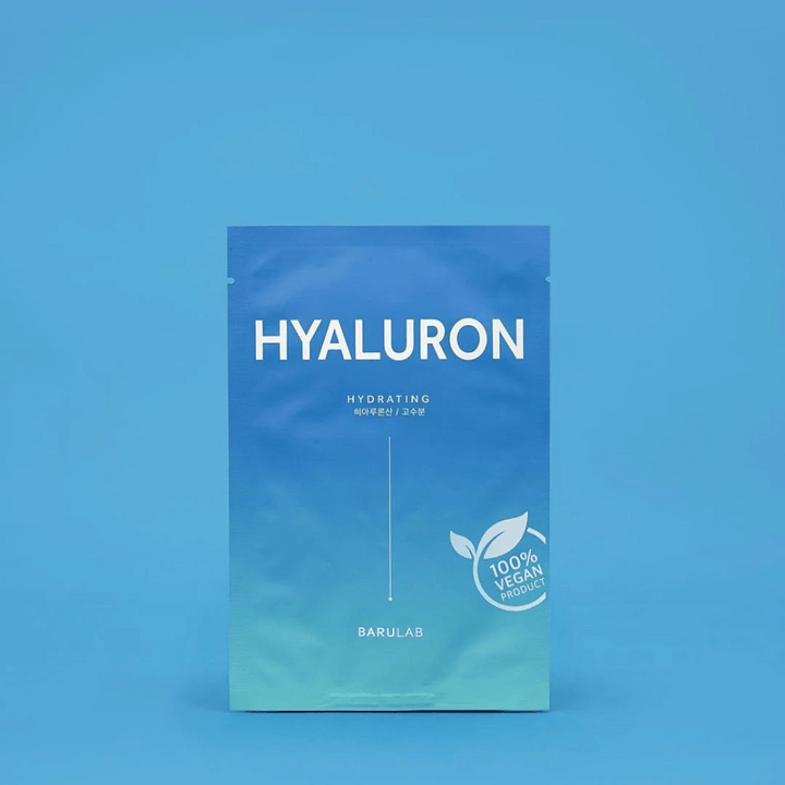 En förpackning av BARULAB "HYALURON Hydrating" mask, märkt som "100% Vegan Product", framför en enhetlig blå bakgrund. Förpackningen har en färggradient från mörkblått till ljusblått.