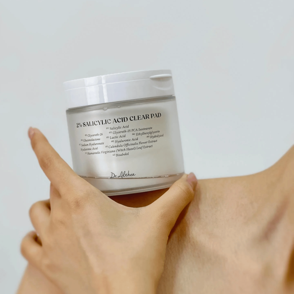 Dr. Althea 2% Salicylic Acid Clear Pad κρατιέται στο χέρι. Pads τονωτικής λοσιόν με 2% σαλικυλικό οξύ που απολεπίζουν απαλά, καταπραΰνουν το δέρμα και βελτιώνουν τη δομή του δέρματος.