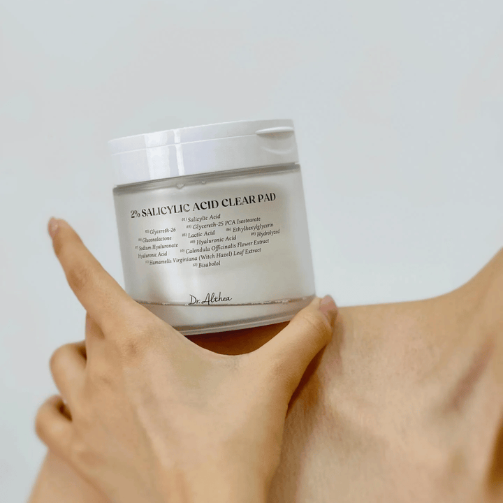 Dr. Althea 2% Salicylic Acid Clear Pad κρατιέται στο χέρι. Pads τονωτικής λοσιόν με 2% σαλικυλικό οξύ που απολεπίζουν απαλά, καταπραΰνουν το δέρμα και βελτιώνουν τη δομή του δέρματος.