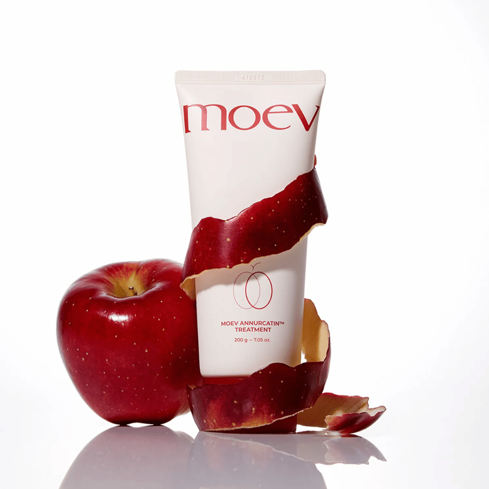 MOEV Annurcatin Treatment μαζί με κόκκινα μήλα – συμβολίζει τη φυσική δύναμη του μήλου Annurca που περιποιείται και προστατεύει τα μαλλιά σε βάθος.