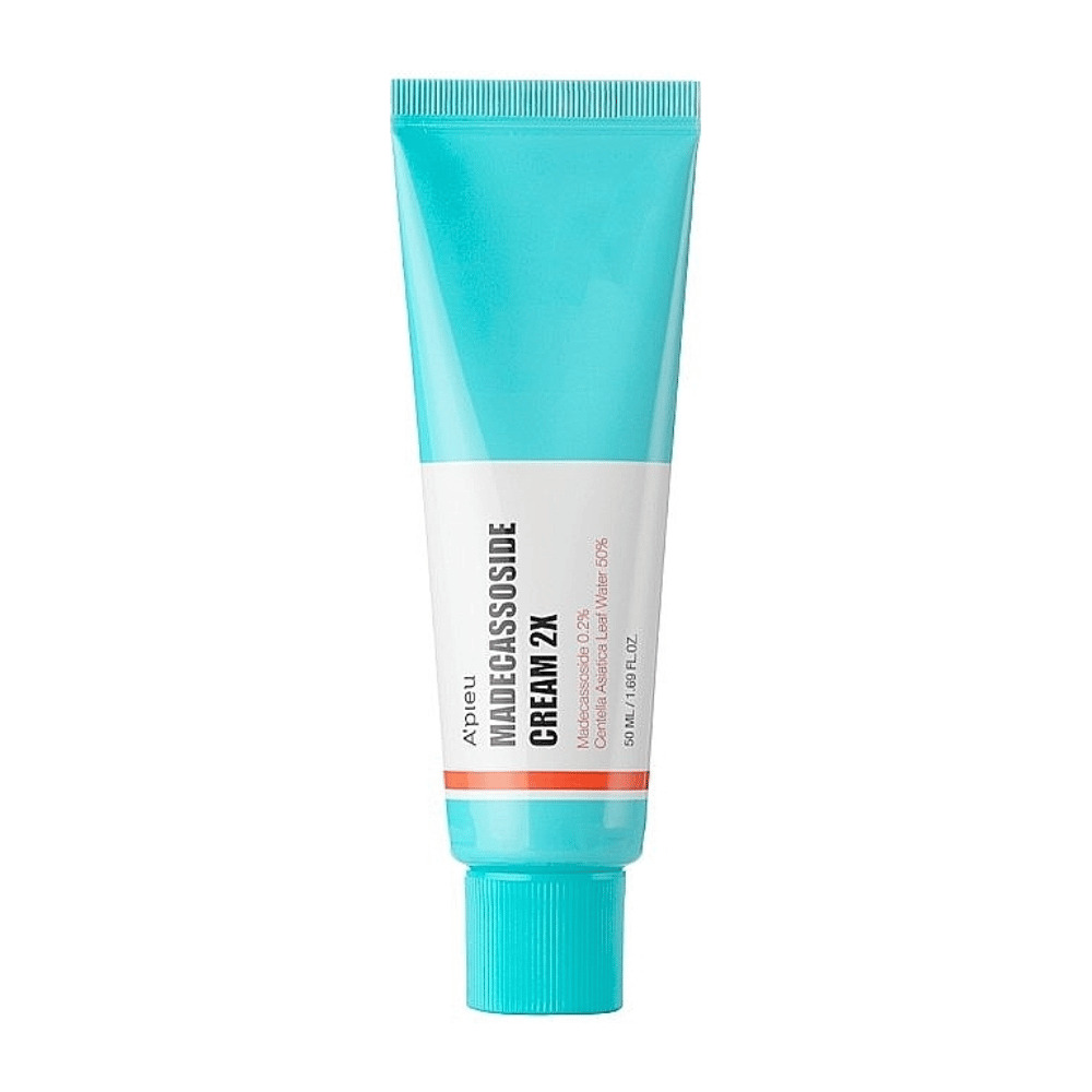 Ένα σωληνάριο με A'PIEU Madecassoside Cream 2X, με ένα ανοιχτό τιρκουάζ χρώμα στην κορυφή που μεταβαίνει σε λευκό προς το κάτω μέρος. Ο σωλήνας έχει ευδιάκριτο κείμενο που αναφέρει τη μάρκα και το όνομα του προϊόντος καθώς και το ενεργό συστατικό Madecassoside 2%. Μια πορτοκαλί χρωματική έμφαση περνά ως γραμμή γύρω από τον σωλήνα. Το προϊόν φαίνεται να είναι μια κρέμα δέρματος που επικεντρώνεται στη φροντίδα και την αποκατάσταση του δέρματος. Το φόντο είναι ουδέτερο για να διατηρεί την εστίαση στο προϊόν.