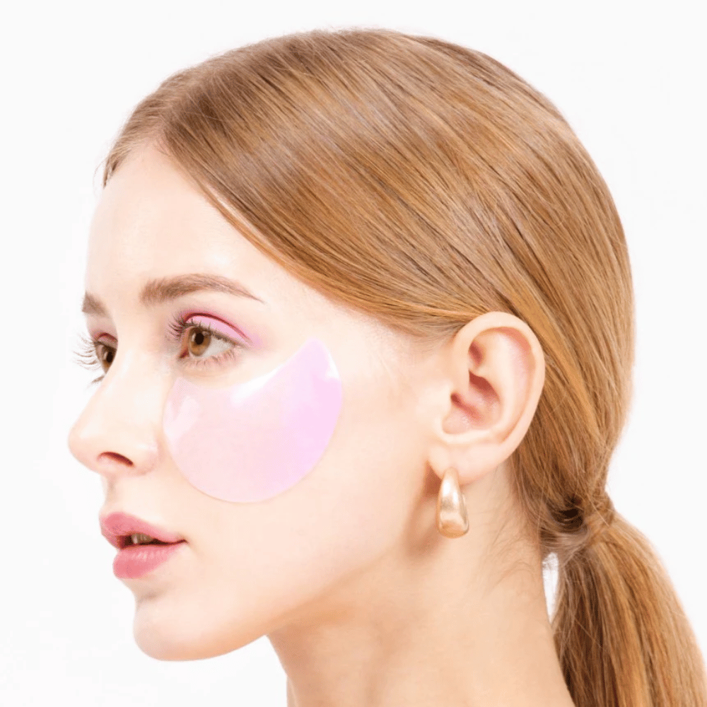 Μοντέλο φοράει ένα ροζ hydrogel eye patch κάτω από το μάτι, ενυδατικό και αναζωογονητικό για το δέρμα.