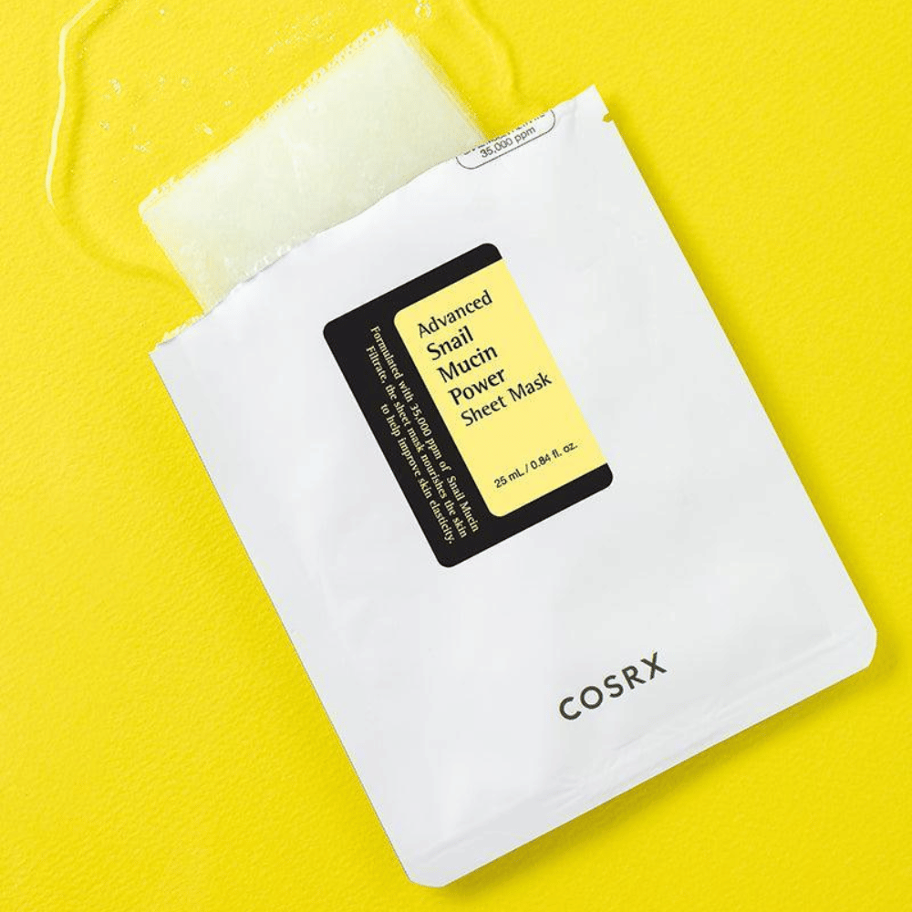 COSRX Advanced Snail Mucin Power Sheet Mask på gul bakgrund, en återfuktande och reparerande ansiktsmask med snigelsekret för ökad elasticitet och lyster.