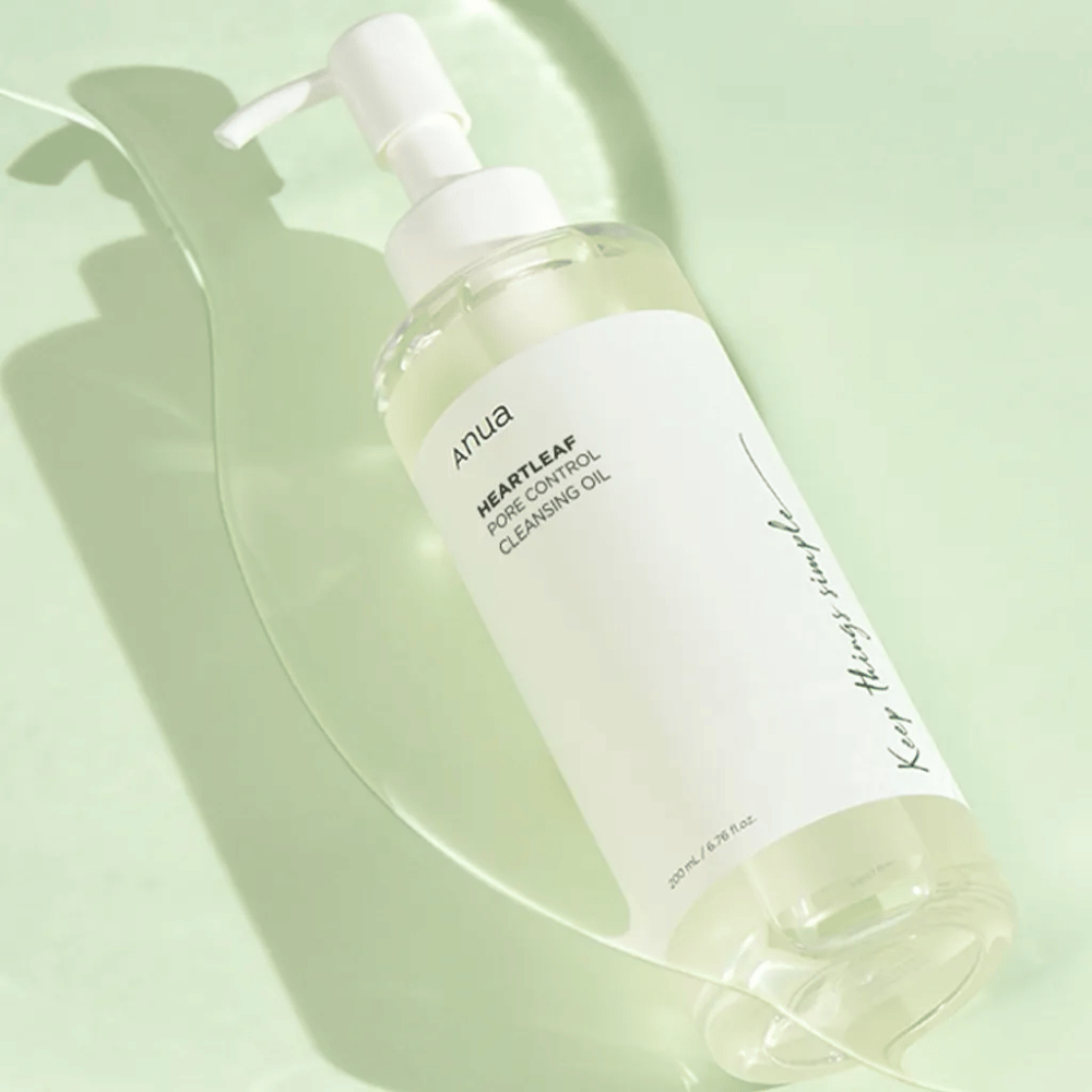 Στην εικόνα φαίνεται ANUA Heartleaf Pore Control Cleansing Oil, ένα λάδι καθαρισμού με σχεδιασμό αντλίας. Το μπουκάλι είναι διάφανο και το περιεχόμενο φαίνεται να έχει ελαφριά, ελαιώδη υφή. Η ετικέτα φέρει το λογότυπο της μάρκας και το όνομα του προϊόντος σε απλό και κομψό κείμενο, συμβάλλοντας σε μια αίσθηση μινιμαλιστικής ομορφιάς και καθαρότητας. Στη σχεδίαση αναγράφεται "Keep things simple", που υποδηλώνει μια φιλοσοφία απλότητας στη ρουτίνα περιποίησης δέρματος. Το μπουκάλι περιέχει 200 ml προϊόντος.