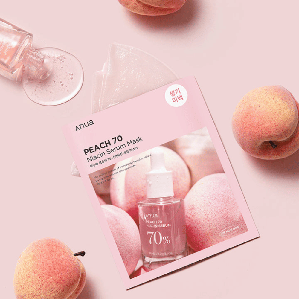 Μια εικόνα της Anua PEACH 70 Niacin Serum Mask, περιτριγυρισμένη από ροδάκινα και ένα μπουκάλι ορού. Η εικόνα έχει ένα απαλό ροζ φόντο, το οποίο συμπληρώνει τη ροζ συσκευασία και αναδεικνύει το προϊόν και τα συστατικά.