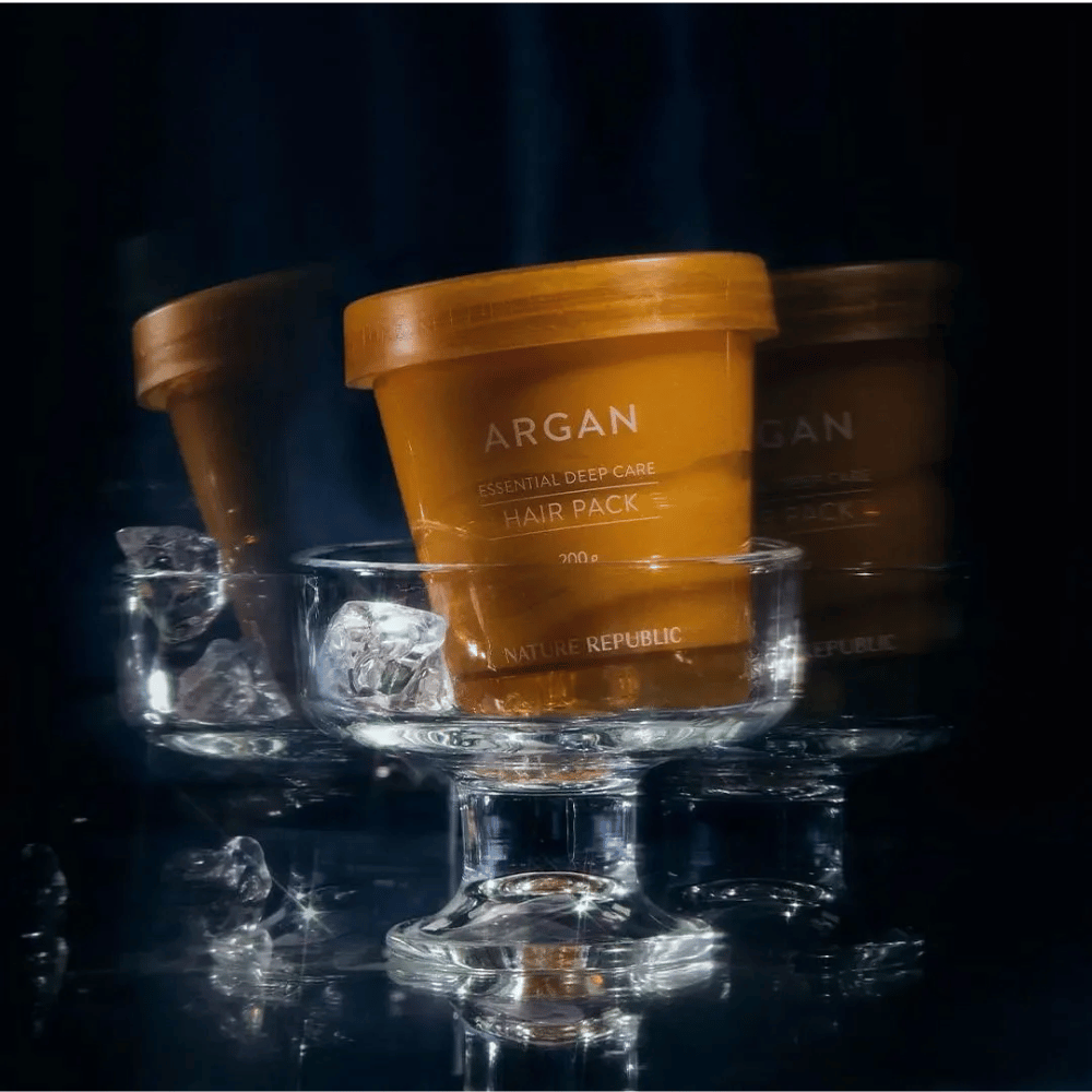 Nature Republic Argan Essential Moisture Repairing Hair Mask τοποθετημένο σε γυάλινο πιάτο με παγάκια – πολυτελής και φροντίδα μάσκα μαλλιών.