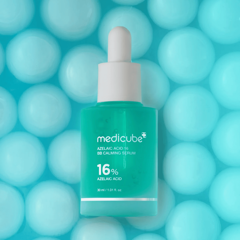 Διαφημιστική εικόνα του Medicube Azelaic Acid 16 BB Calming Serum σε τιρκουάζ φόντο με απαλές σφαίρες που συμβολίζουν την ενυδάτωση, την καταπραϋντική δράση και την ομοιόμορφη υφή της επιδερμίδας.
