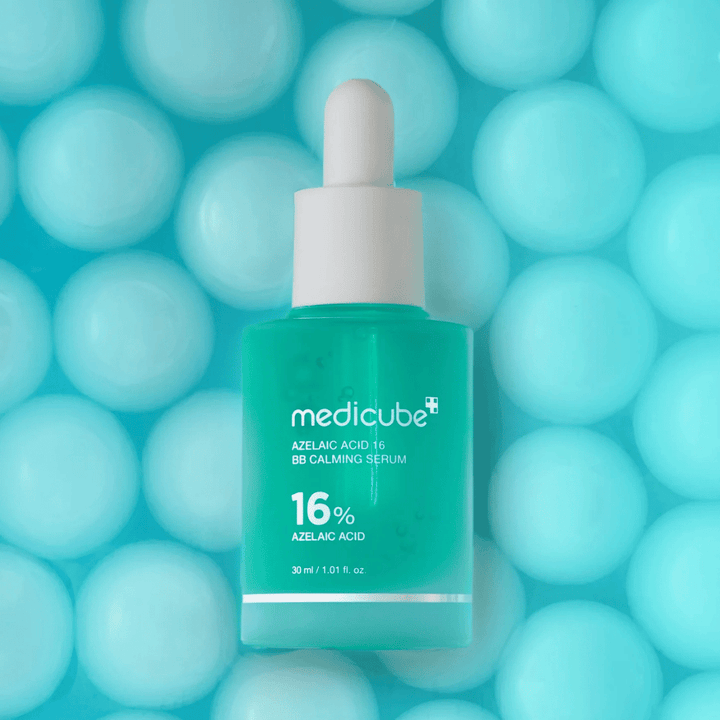 Διαφημιστική εικόνα του Medicube Azelaic Acid 16 BB Calming Serum σε τιρκουάζ φόντο με απαλές σφαίρες που συμβολίζουν την ενυδάτωση, την καταπραϋντική δράση και την ομοιόμορφη υφή της επιδερμίδας.
