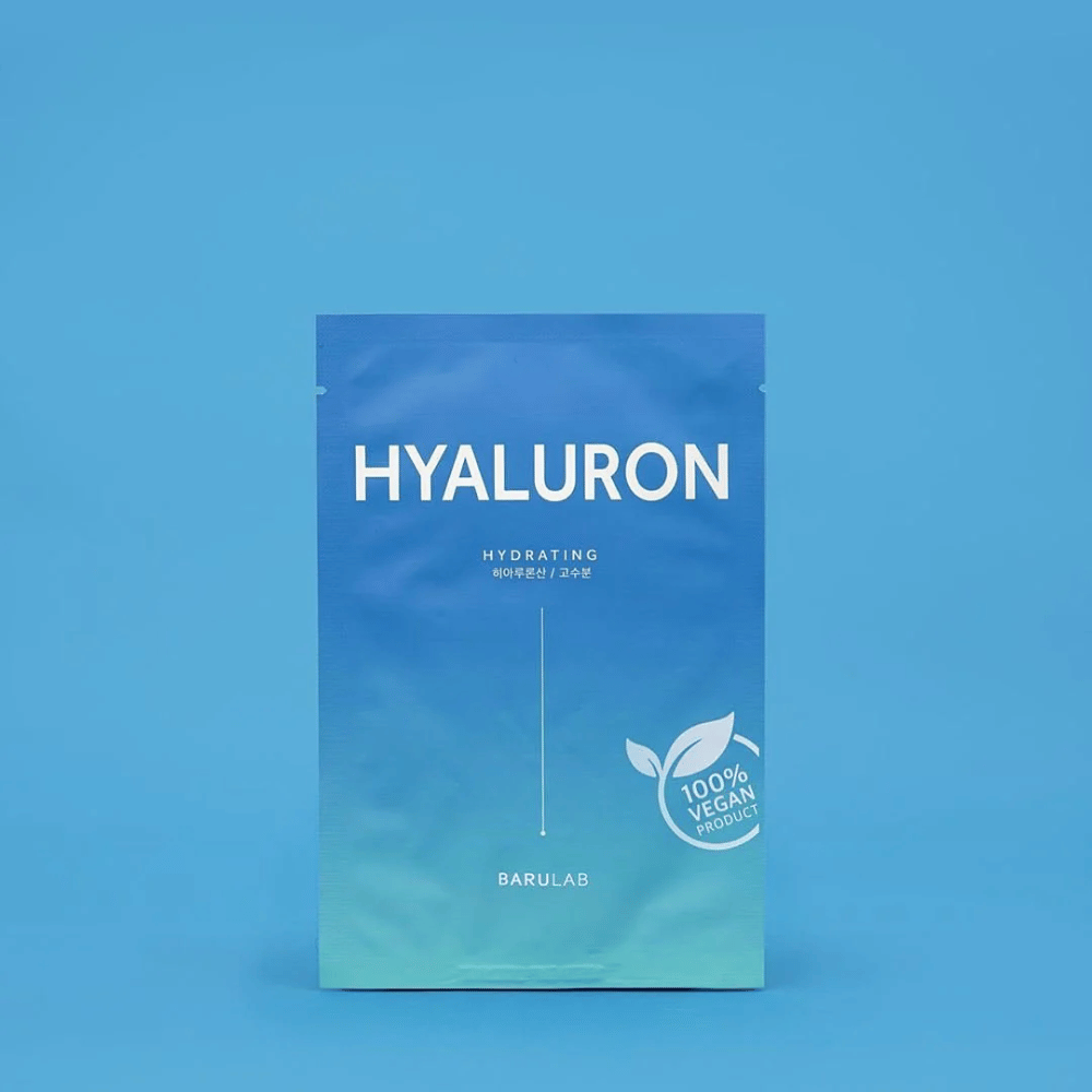 Μια συσκευασία της μάσκας "HYALURON Hydrating" BARULAB, με την ένδειξη "100% Vegan Product", μπροστά από ένα ομοιόμορφο μπλε φόντο. Η συσκευασία έχει ένα χρωματικό διαβαθμισμένο από σκούρο μπλε σε ανοιχτό μπλε.