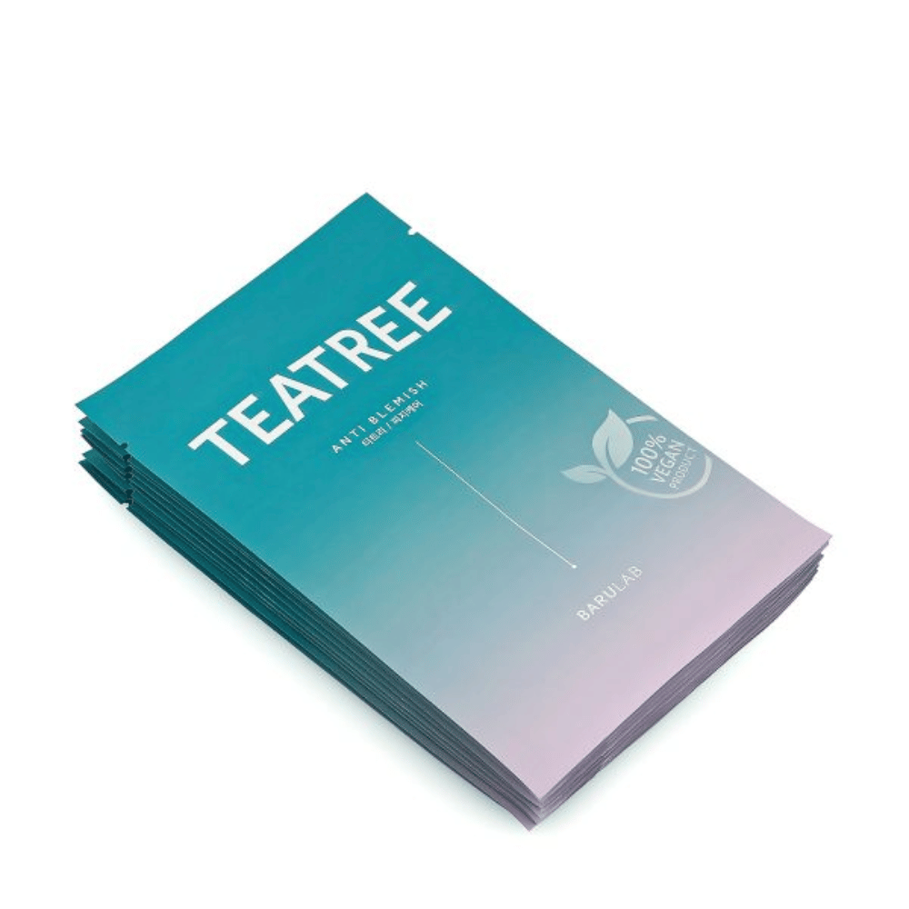 Ένας σωρός από συσκευασίες από BARULAB μάσκες "TEATREE Anti Blemish", όλες με σήμανση "100% Vegan Product". Οι συσκευασίες έχουν ομοιόμορφο τιρκουάζ χρώμα.