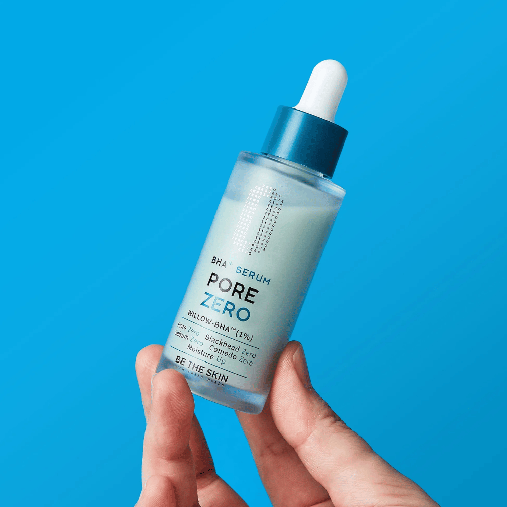 Be The Skin BHA+ Pore Zero Serum κρατιέται στο χέρι σε μπλε φόντο
