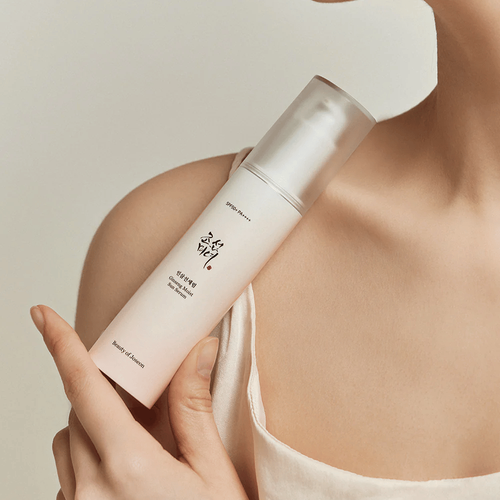 Μια γυναίκα που κρατάει ένα μπουκάλι Beauty of Joseon's Ginseng Moist Sun Serum SPF 50+ PA++++, που παρέχει SPF 50+ PA++++ προστασία και οφέλη περιποίησης δέρματος.