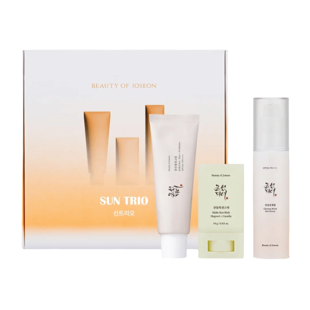 Beauty of Joseon - Το Sun Trio παρουσιάζει συσκευασία δώρου με τρία αντηλιακά προϊόντα: Relief Sun Rice + Probiotics, Matte Sun Stick Mugwort + Camellia και Ginseng Moist Sun Serum μπροστά από μια συσκευασία με κλίση σε λευκό και πορτοκαλί.