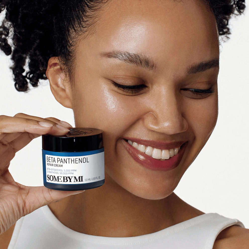 Μοντέλο με λαμπερό δέρμα κρατάει SOME BY MI Beta Panthenol Repair Cream – κορεάτικη κρέμα προσώπου που ενισχύει το φραγμό του δέρματος και ενυδατώνει.