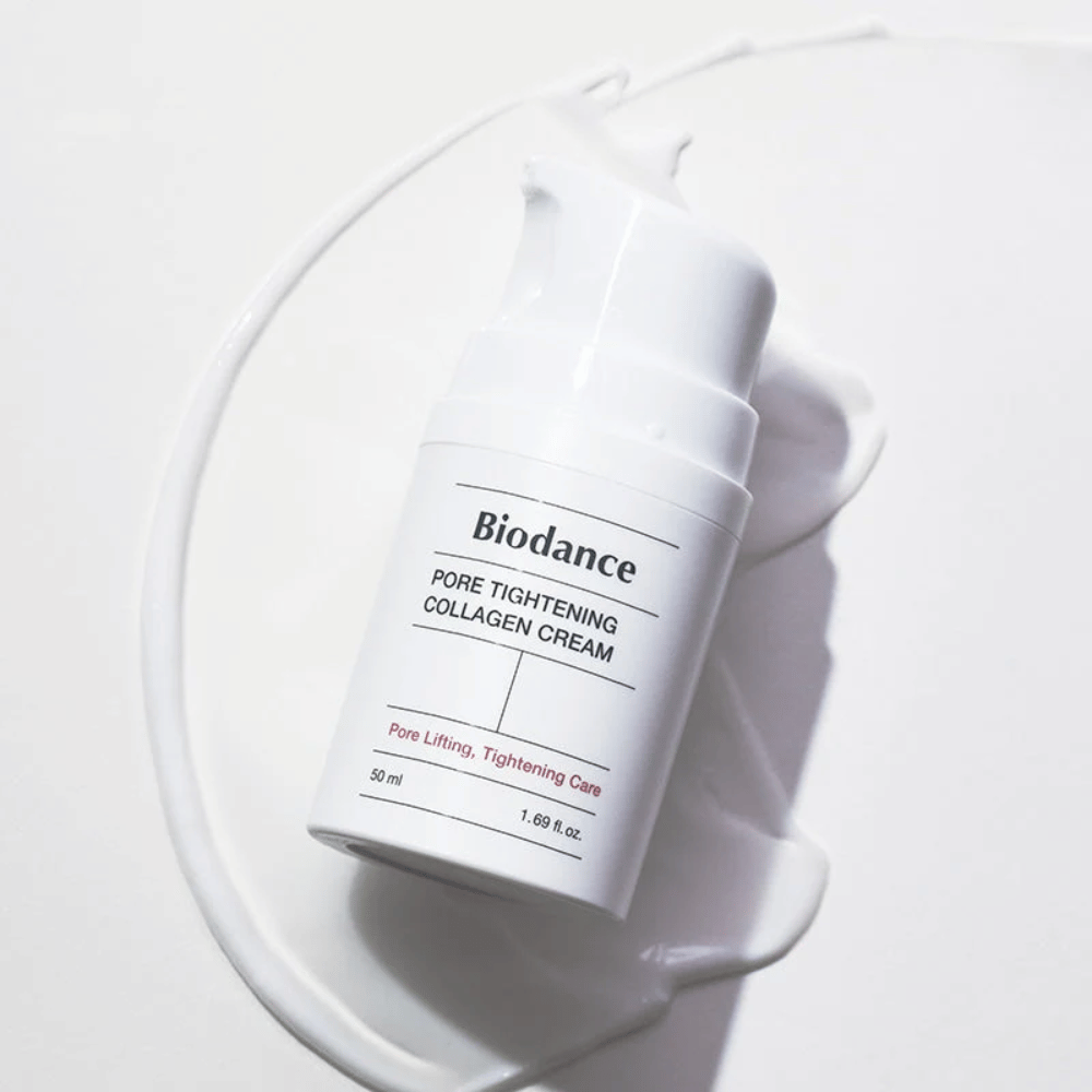 Biodance Σύσφιξη Πόρων Collagen Cream σε λευκό μπουκάλι με αντλία, τοποθετημένο πάνω σε στροβιλισμό λευκής κρέμας.