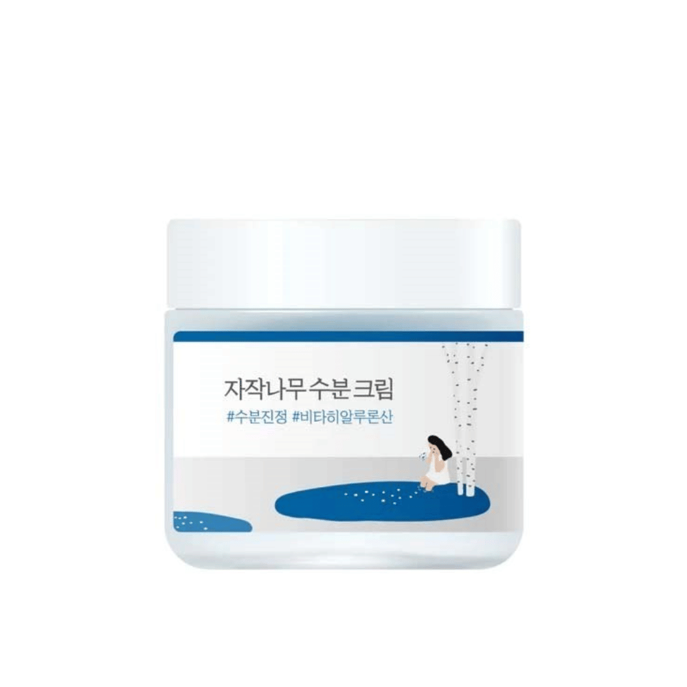 Round Lab Birch Juice Moisturizing Cream σε διαφανές βάζο με λευκό καπάκι και μπλε ετικέτα με εικονογράφηση από σημύδα και κορίτσι, απομονωμένο σε λευκό φόντο.