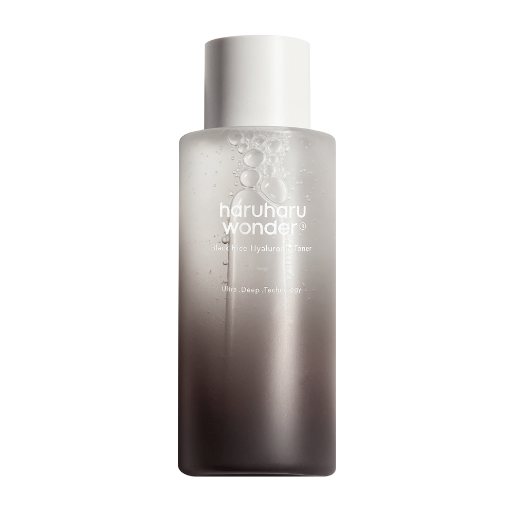 Ένα μπουκάλι haruharu wonder Black Rice Hyaluronic Toner με μια γκρι προς λευκή χρωματική διαβάθμιση και σταγόνες νερού στην επιφάνεια, σε λευκό φόντο.