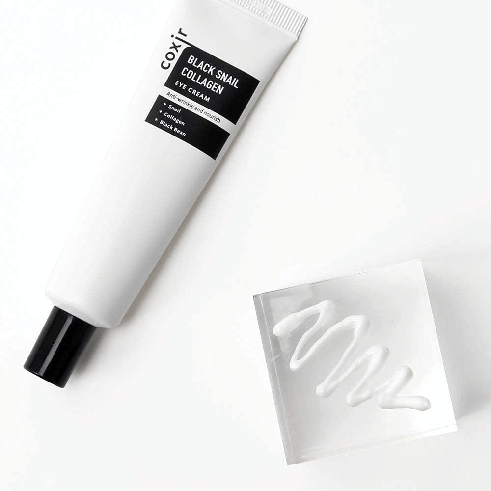 Αυτή είναι μια εικόνα του "Black Snail Collagen Eye Cream". Είναι μια κρέμα ματιών που περιέχει συστατικά όπως εκχύλισμα σαλιγκαριού και κολλαγόνο, τα οποία είναι γνωστά για τις ενυδατικές και θρεπτικές τους ιδιότητες. Το προϊόν προωθείται για να προσφέρει στο δέρμα ελαστικότητα και θρέψη.