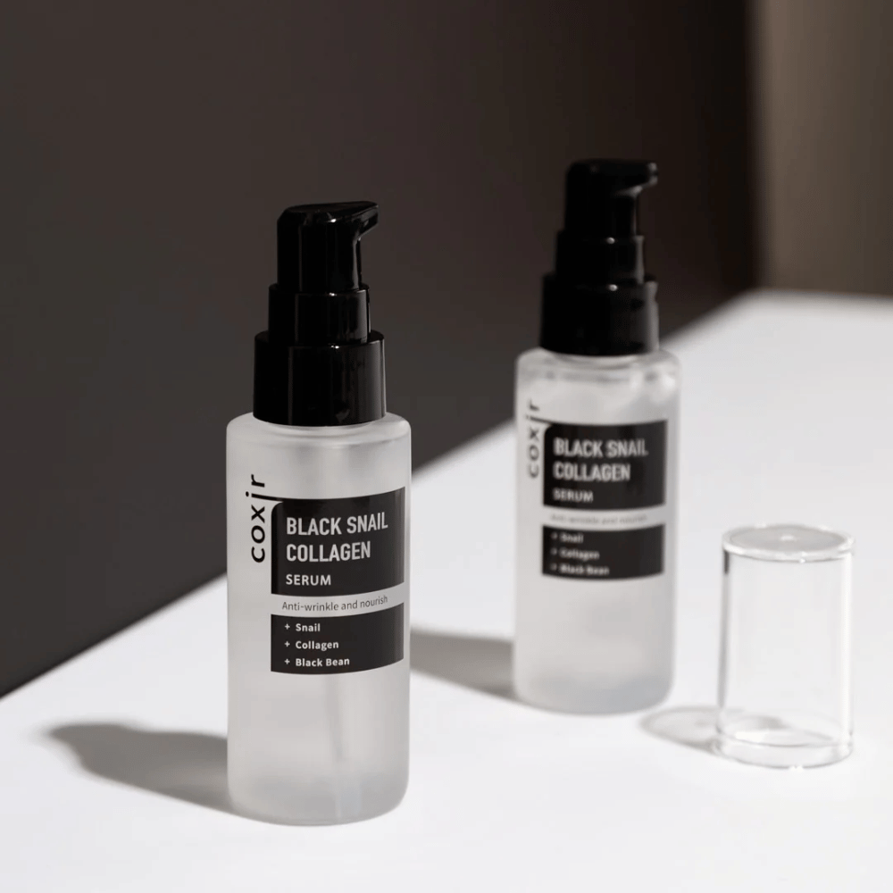  Η εικόνα δείχνει δύο μπουκάλια του "Black Snail Collagen Serum". Ο ορός προωθείται ως κατά των ρυτίδων και θρεπτικός, με συστατικά όπως εκχύλισμα σαλιγκαριού, κολλαγόνο και μαύρο φασόλι.