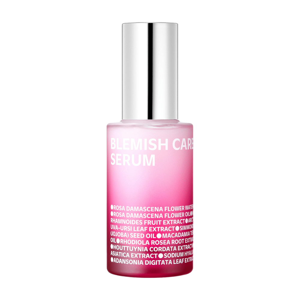 Ένα μοναχικό μπουκάλι Blemish Care Serum με σχεδιασμό σε ροζ αποχρώσεις και ασημένιο καπάκι, στέκεται σε λευκό φόντο. Το κείμενο στο μπουκάλι αναφέρει συστατικά όπως ροδόνερο, έλαια και εκχυλίσματα, τυπωμένο με λευκά γράμματα στο μπροστινό μέρος.