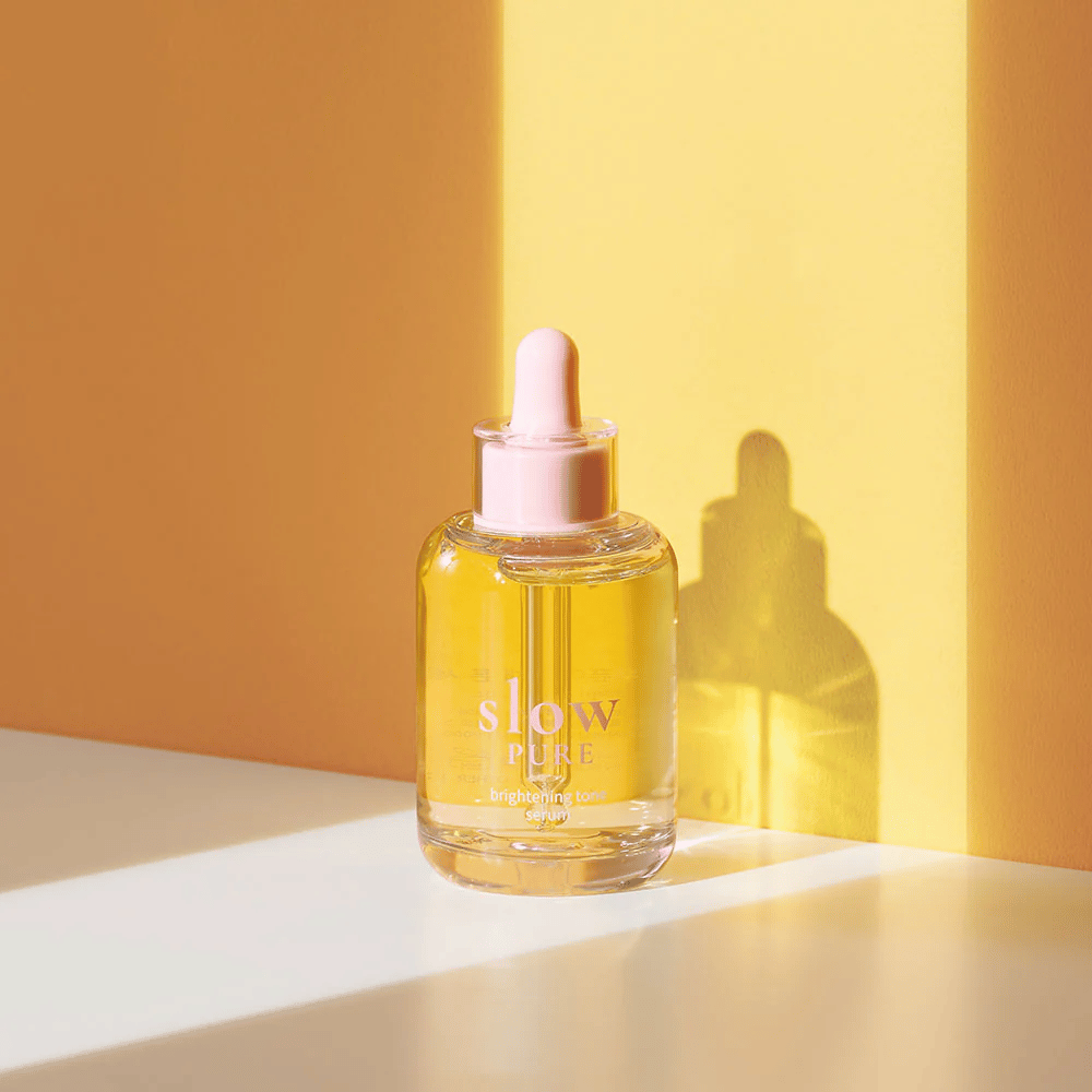 Slow Pure Brightening Tone Serum σε ηλιόλουστο κίτρινο φως, συμβολίζει τη λάμψη και την ενέργεια για το δέρμα.