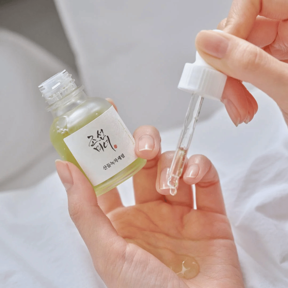 Χέρι ρίχνει Beauty of Joseon Calming Serum Green Tea + Panthenol στο δέρμα – καταπραϋντικός κορεάτικος ορός για ευαίσθητο δέρμα.