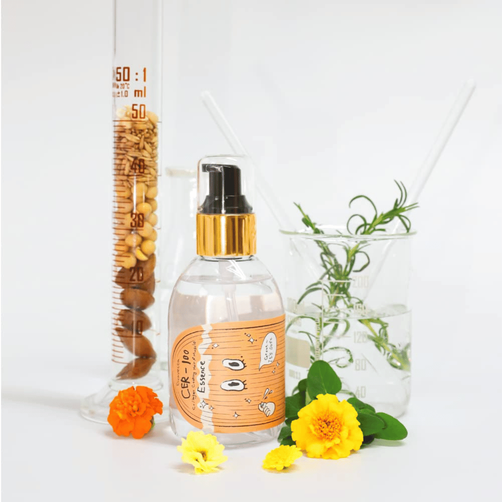 Το CER-100 Hair Essence μαζί με λουλούδια και εργαστηριακά γυάλινα σκεύη που αναδεικνύουν τα συστατικά και τη φροντίδα των μαλλιών.