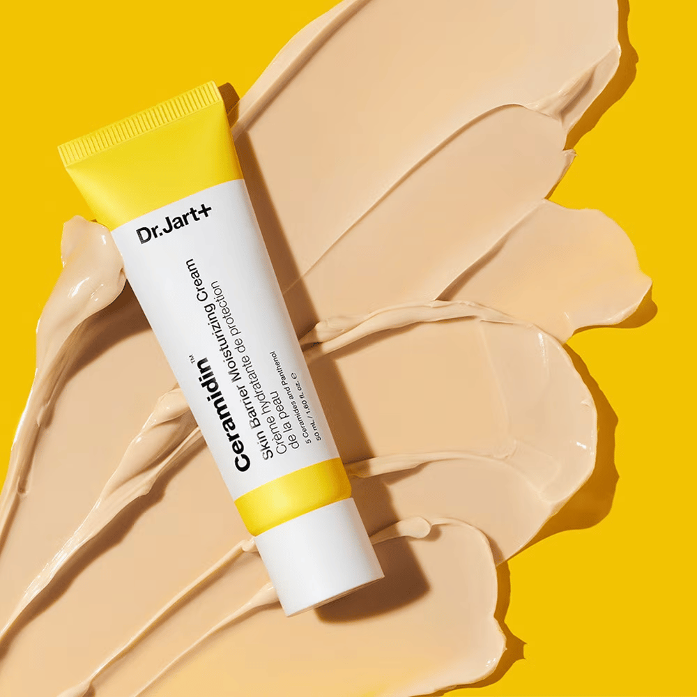 Σωληνάριο με Dr. Jart+ Ceramidin Skin Barrier Moisturizing Cream σε κίτρινο φόντο με απλωμένη κρέμα.