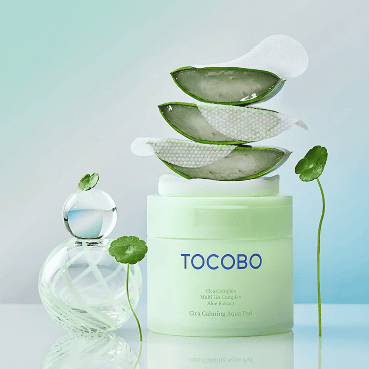 Το TOCOBO Cica Calming Aqua Pad παρουσιάζεται μαζί με toner pads, αλόη βέρα και centella asiatica. Η εικόνα αναδεικνύει τα ενυδατικά και καταπραϋντικά συστατικά του προϊόντος.