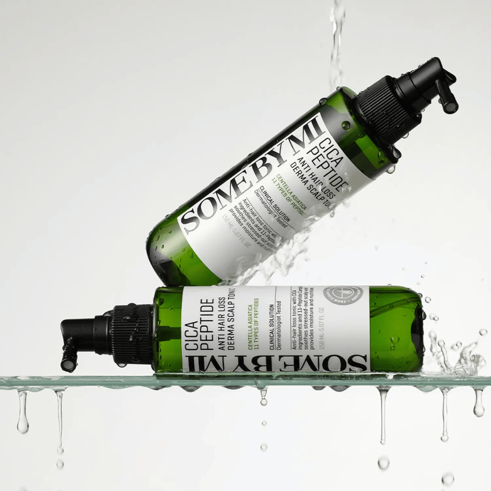 Δύο μπουκάλια SOME BY MI Cica Peptide Anti Hair Loss Derma Scalp Tonic βρίσκονται μέσα και πάνω από το νερό με σταγόνες που πιτσιλίζουν, πράσινα μπουκάλια με μαύρο ακροφύσιο ψεκασμού και λευκή ετικέτα.