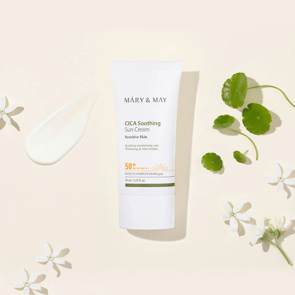 Το Mary&May CICA Soothing Sun Cream SPF50+ PA++++ παρουσιάζεται μαζί με υφή κρέμας, φύλλα centella και λευκά άνθη. Η εικόνα αναδεικνύει τις καταπραϋντικές ιδιότητες του προϊόντος και την έμφαση στο ευαίσθητο δέρμα.
