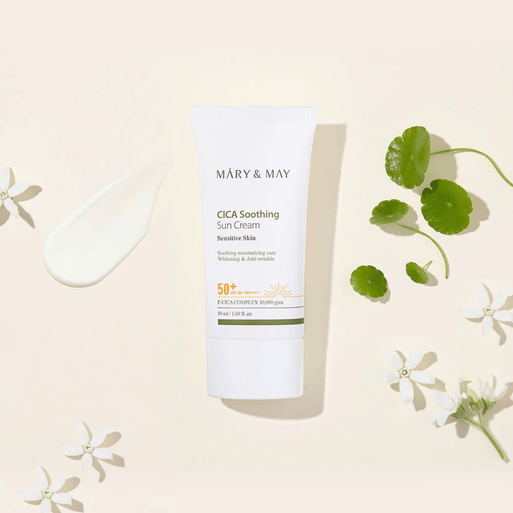 Το Mary&May CICA Soothing Sun Cream SPF50+ PA++++ παρουσιάζεται μαζί με υφή κρέμας, φύλλα centella και λευκά άνθη. Η εικόνα αναδεικνύει τις καταπραϋντικές ιδιότητες του προϊόντος και την έμφαση στο ευαίσθητο δέρμα.
