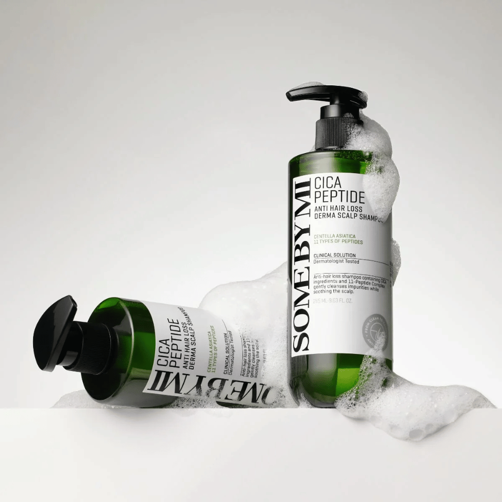 Δύο μπουκάλια SOME BY MI Cica Peptide Anti Hair Loss Derma Scalp Shampoo καλυμμένα με αφρό, στέκονται και ξαπλώνουν σε λευκό φόντο.