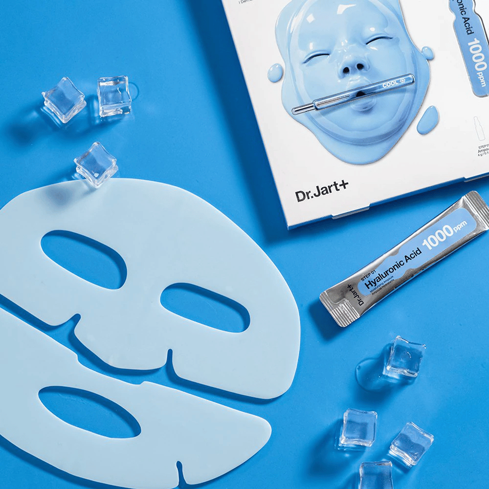 Dr.Jart+ Cryo Rubber Moisturizing Mask με δίδυμη μπλε μάσκα από καουτσούκ, παγάκια, αμπούλα υαλουρονικού οξέος και συσκευασία σε μπλε φόντο.