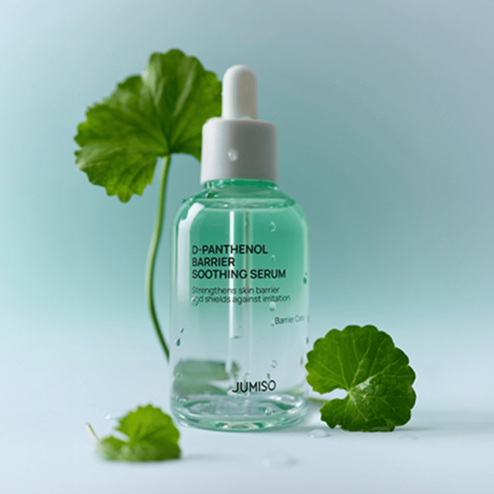 Jumiso D-Panthenol Barrier Soothing Serum σε διαφανή γυάλινη φιάλη με πιπέτα, τοποθετημένη με πράσινα φύλλα στο φόντο.