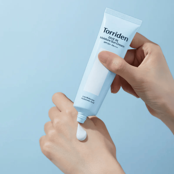 Torriden DIVE-IN Moisture Sun Cream SPF50+ PA++++ εφαρμόζεται στο χέρι για να δείξει την ελαφριά και κρεμώδη υφή της ενυδατικής αντηλιακής κρέμας.