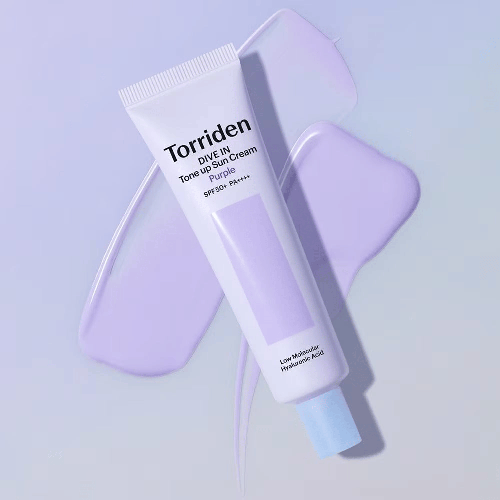 Torriden DIVE IN Tone Up Sun Cream Purple τοποθετημένο πάνω σε απλωμένη μωβ κρέμα που τονίζει την εξομαλυντική για τον τόνο και χαρίζουσα λάμψη δράση.