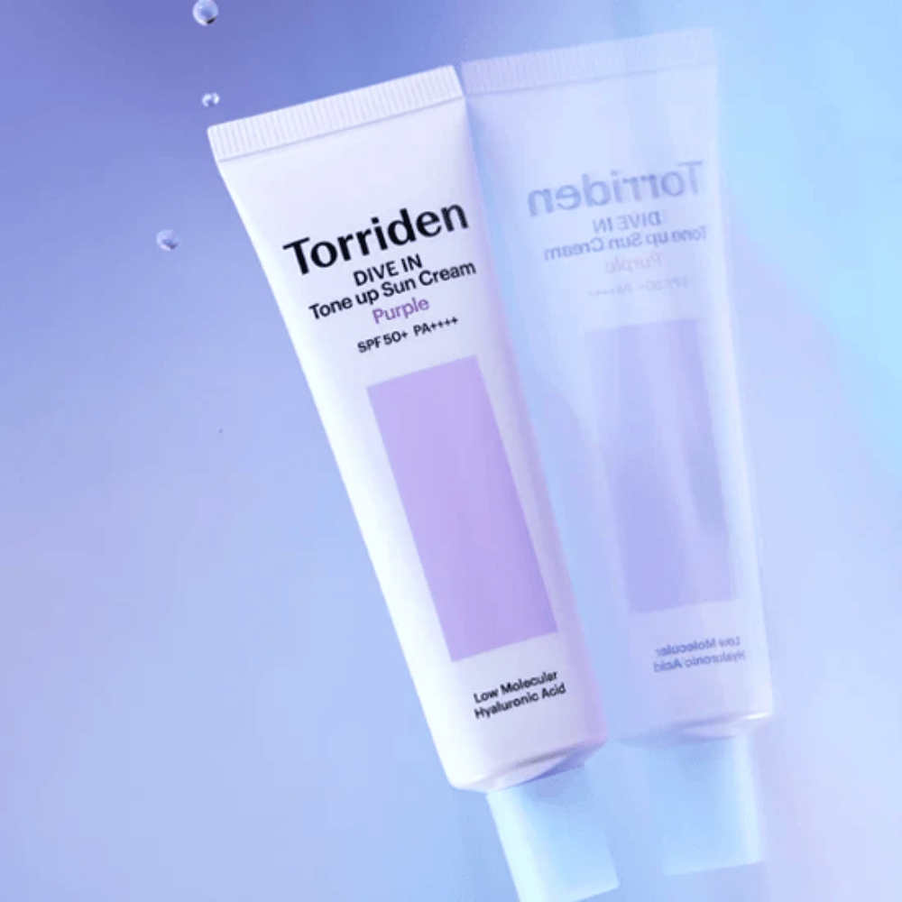 Torriden DIVE IN Tone Up Sun Cream Purple SPF50+ PA++++ φωτογραφημένο σε απαλό μωβ φόντο που αναδεικνύει τον σχεδιασμό του προϊόντος που αντανακλά το φως.