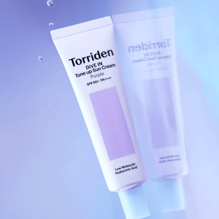 Torriden DIVE IN Tone Up Sun Cream Purple SPF50+ PA++++ φωτογραφημένο σε απαλό μωβ φόντο που αναδεικνύει τον σχεδιασμό του προϊόντος που αντανακλά το φως.