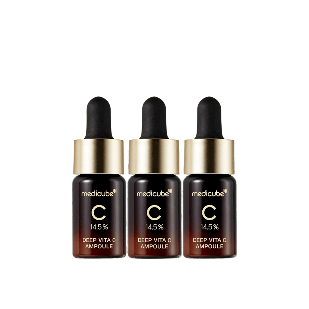 Τρία μπουκάλια από Medicube Deep Vita C Ampoule, με 14,5% βιταμίνη C, τοποθετημένα στη σειρά. Τα μπουκάλια έχουν κομψό σχεδιασμό με σκούρα καφέ βάση και χρυσό καπάκι. Ιδανικό για φωτεινότερο τόνο δέρματος και πιο ομοιόμορφη υφή δέρματος.
