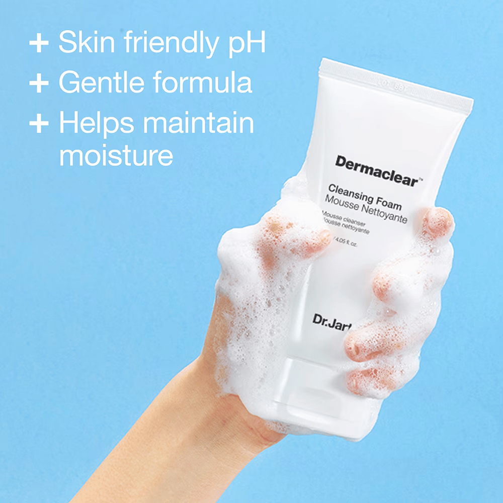 Χέρι καλυμμένο με αφρό κρατάει το Dr.Jart+ Dermaclear Cleansing Foam σε μπλε φόντο, με κείμενο που αναδεικνύει το φιλικό προς το δέρμα pH, την ήπια φόρμουλα και τις υγραντικές ιδιότητες.