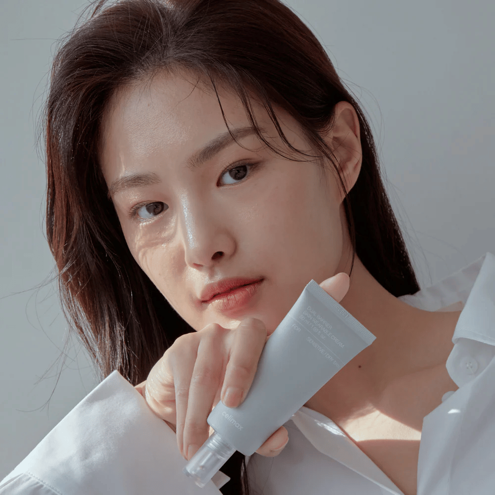 Μοντέλο που κρατάει Celimax Dual Barrier Skin Wearable Cream, καταπραϋντική και ενισχυτική κρέμα προσώπου για ευαίσθητο και ξηρό δέρμα.