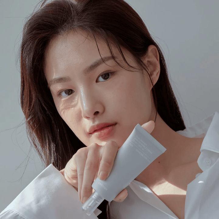 Μοντέλο που κρατάει Celimax Dual Barrier Skin Wearable Cream, καταπραϋντική και ενισχυτική κρέμα προσώπου για ευαίσθητο και ξηρό δέρμα.