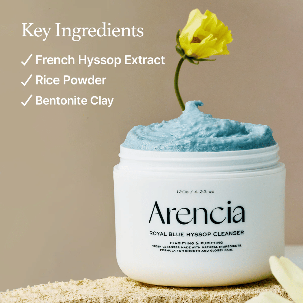 Εικόνα του βάζου "Arencia Royal Blue Hyssop Cleanser" γεμάτο με μπλε κρέμα καθαρισμού. Ένα κίτρινο λουλούδι προεξέχει από την κρέμα. Το κείμενο στην εικόνα αναδεικνύει τρία βασικά συστατικά: Εκχύλισμα Γαλλικού Ύσσου, Σκόνη Ρυζιού και Άργιλο Μπεντονίτη.