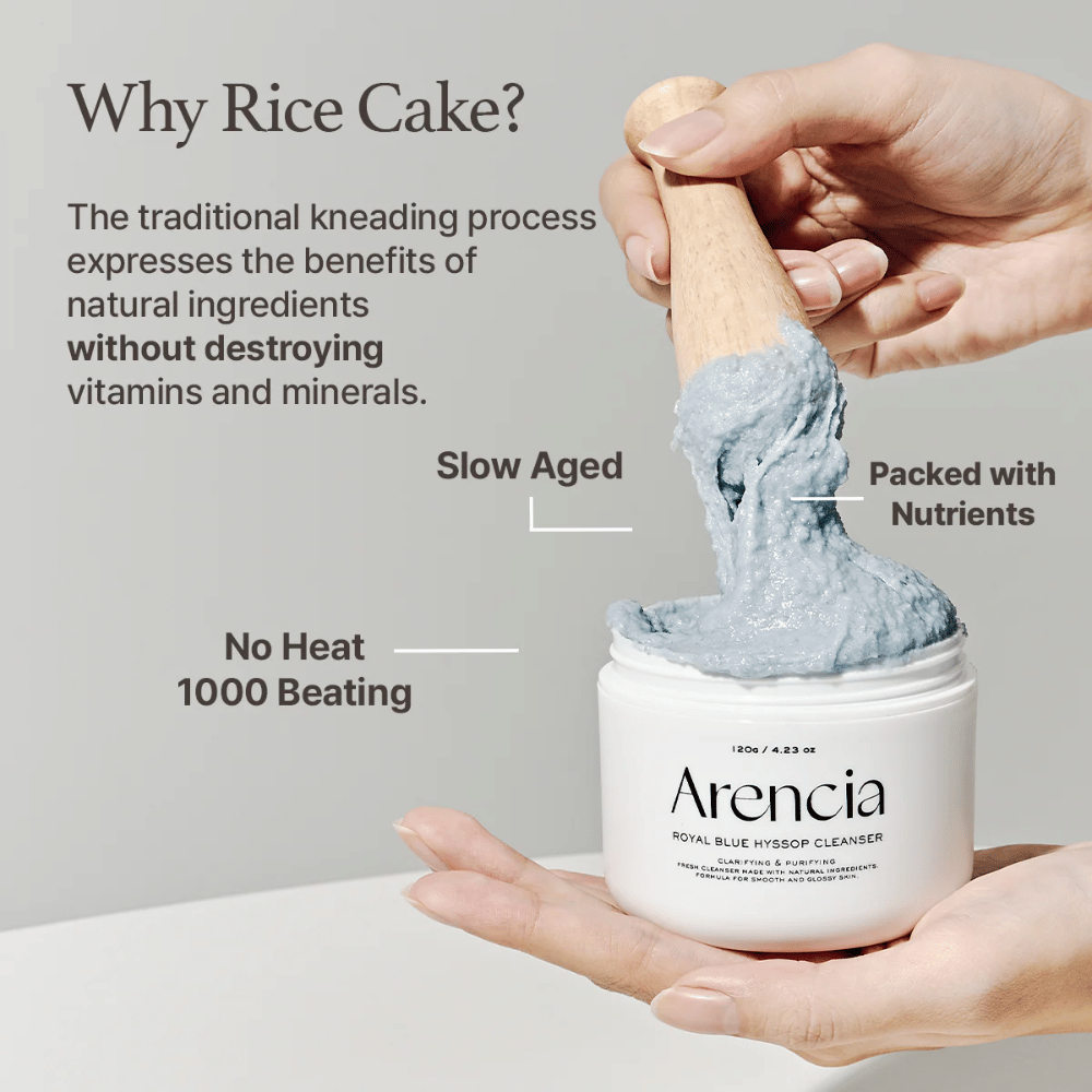 Χέρι που κρατά το βάζο καθαρισμού "Arencia Royal Blue Hyssop Cleanser" με μια ξύλινη κουτάλα που σηκώνει την μπλε, πάστα καθαρισμού που μοιάζει με μοτσί. Το κείμενο στην εικόνα περιγράφει τα οφέλη της διαδικασίας ρυζιού, όπως "Χωρίς Θερμότητα", "1000 Χτυπήματα", "Αργή Ωρίμανση" και "Γεμάτο Θρεπτικά Συστατικά".