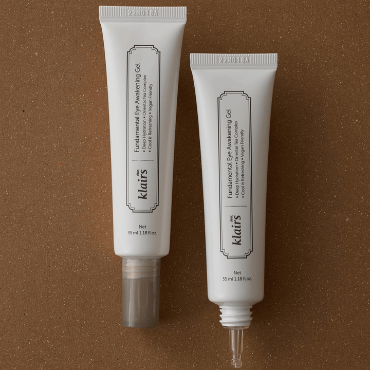 Εικόνα προϊόντος που δείχνει το Klairs Fundamental Eye Awakening Gel σε δύο εκδοχές – ένα κλειστό σωληνάριο και ένα ανοιχτό σωληνάριο που αναδεικνύει τη στενή άκρη εφαρμογής. Η συσκευασία έχει μινιμαλιστικό λευκό σχεδιασμό και προβάλλει την έμφαση του προϊόντος στην ενυδάτωση, τη δροσερή αίσθηση και την αναζωογονητική φροντίδα για την περιοχή των ματιών.