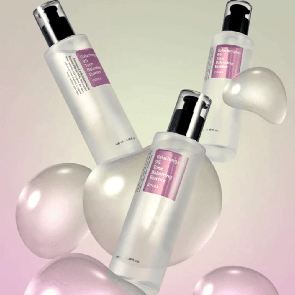Τρία μπουκάλια του COSRX Galactomyces 95 Tone Balancing Essence περιτριγυρισμένα από φωτεινές φυσαλίδες. Ουσία βελτίωσης της επιδερμίδας που εξομαλύνει τον τόνο του δέρματος και δίνει φυσική λάμψη.