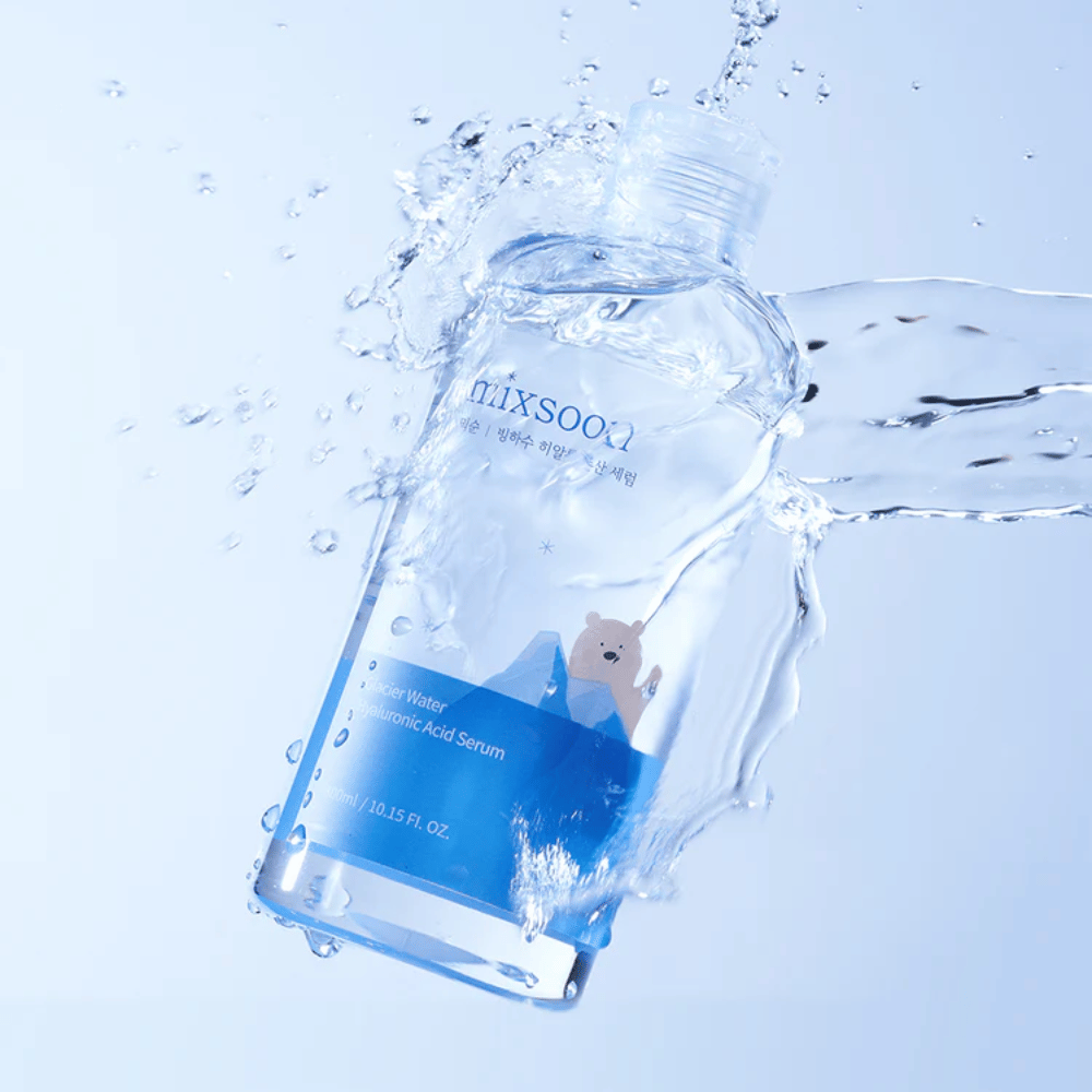 Mixsoon Glacier Water Hyaluronic Acid Serum-μπουκάλι με μπλε ετικέτα και μοτίβο πολικής αρκούδας περιτριγυρισμένο από πιτσιλιές νερού σε ανοιχτό μπλε φόντο.