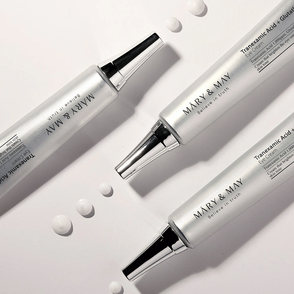Στυλιζαρισμένη εικόνα προϊόντος της Mary&May Tranexamic Acid + Glutathione Eye Cream που δείχνει την υφή της κρέμας και την εστίαση στη λεύκανση της φροντίδας των ματιών.